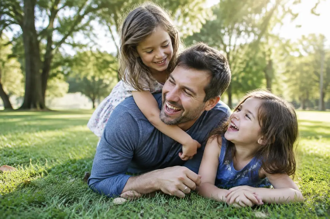 Father playing with his two daughters in the park