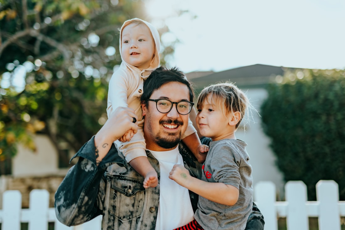 Father carrying his two children outdoors