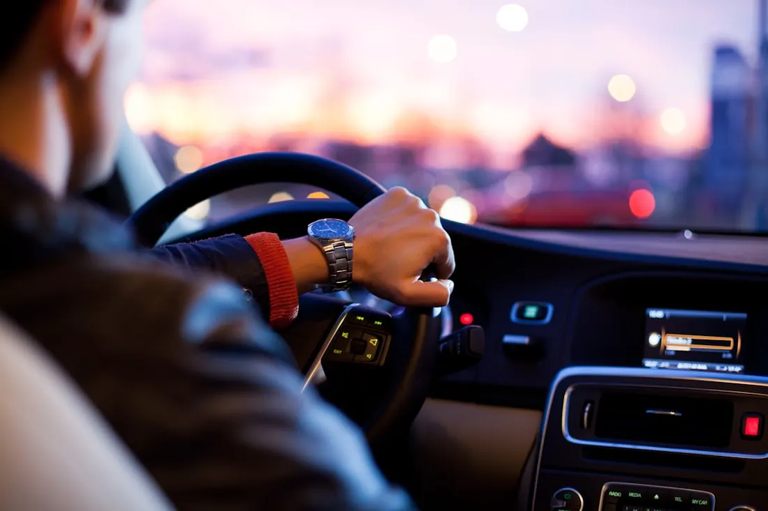 Driving at dusk — hands on the wheel